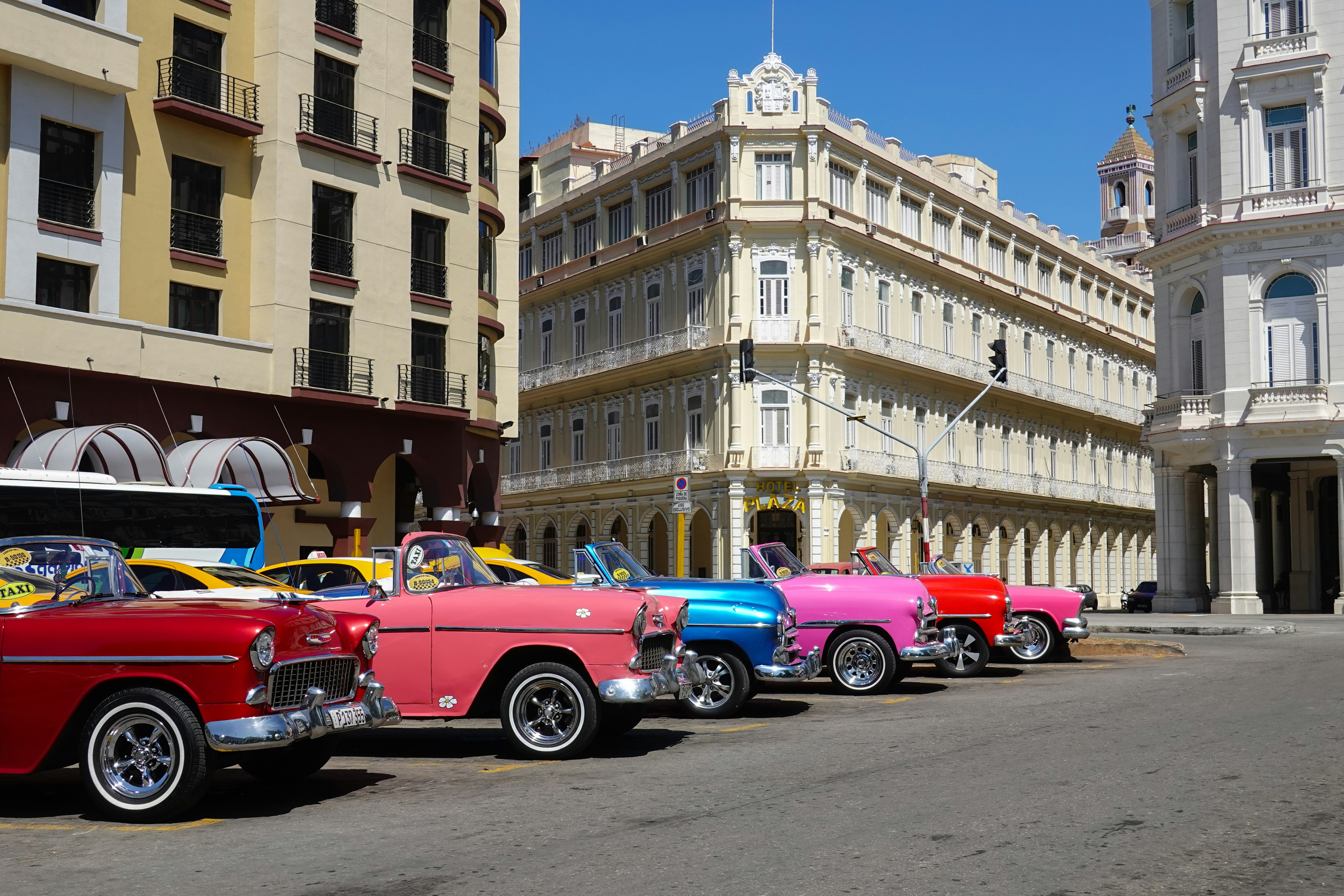 red vintage car on road near building during daytime